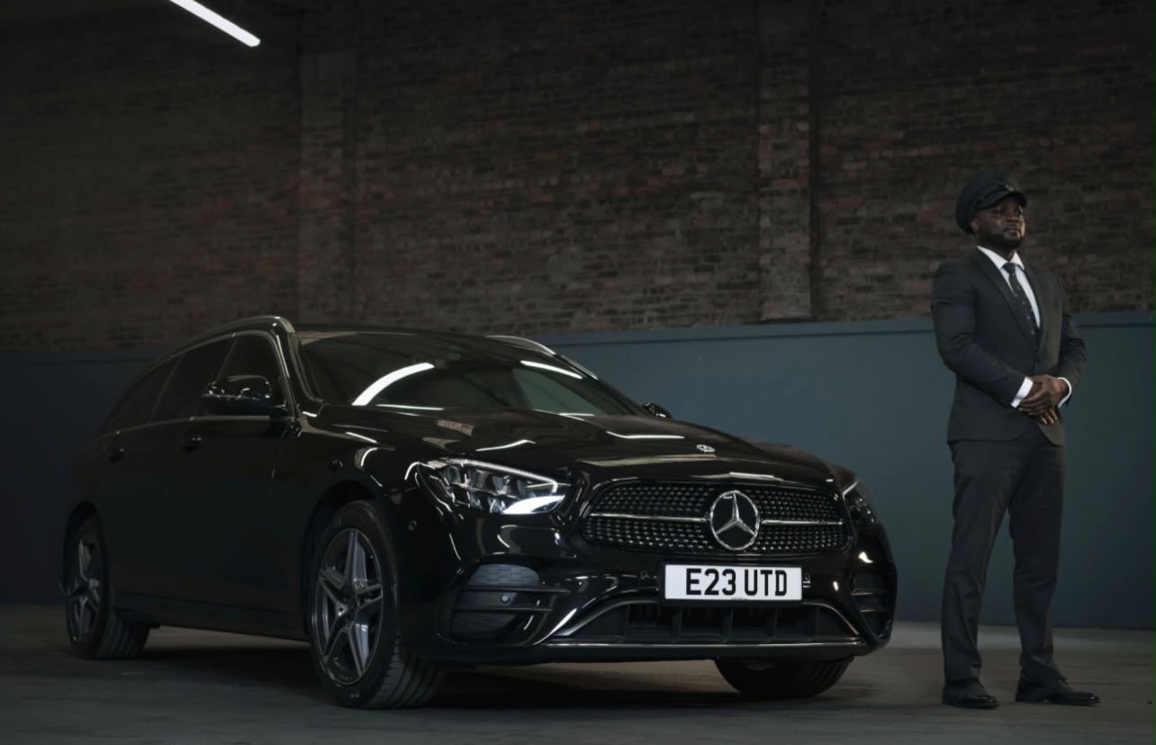 MDS Arabama chauffeur standing beside a black Mercedes E-Class